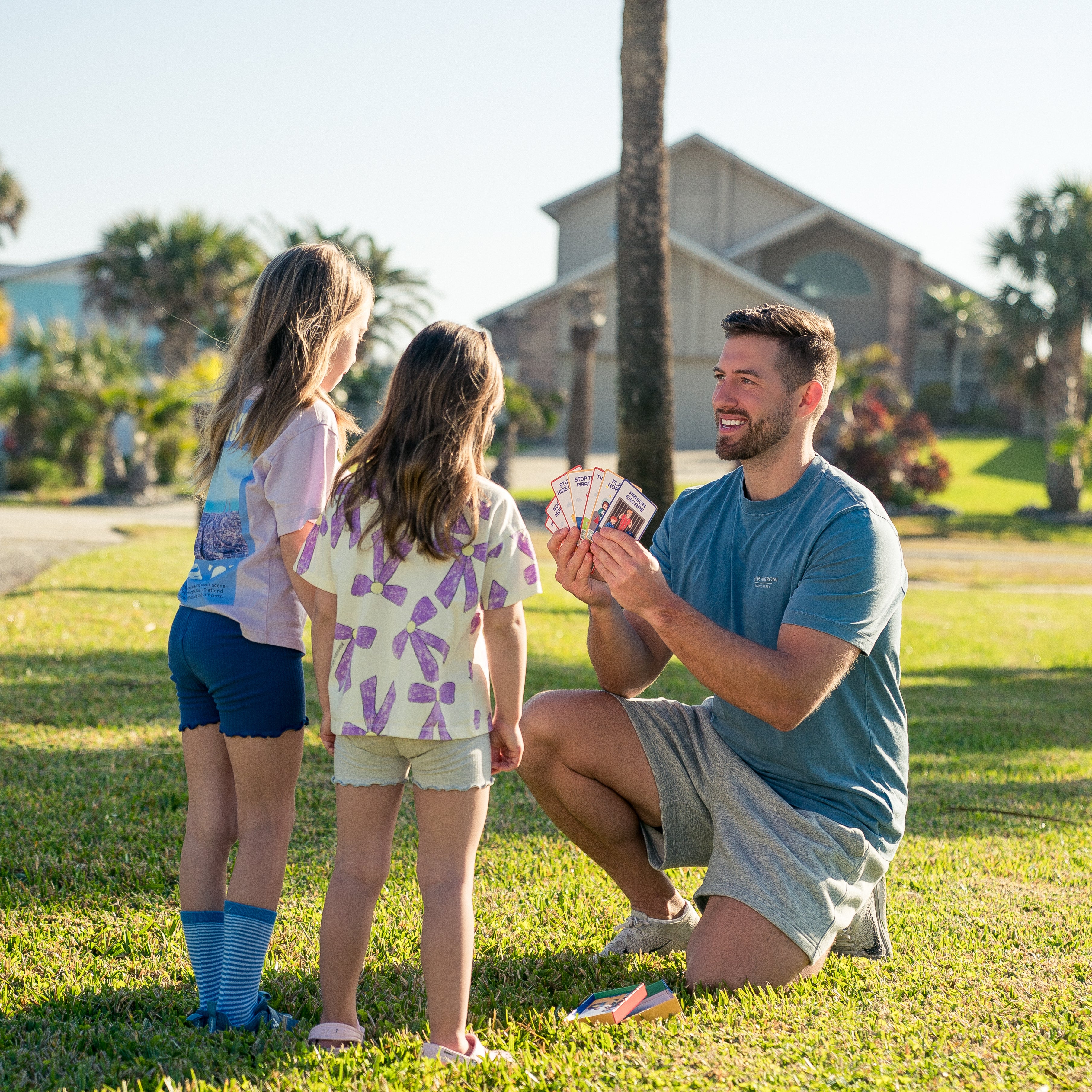 Kevin and his daughters choosing a PlayBoost game card on the grass
