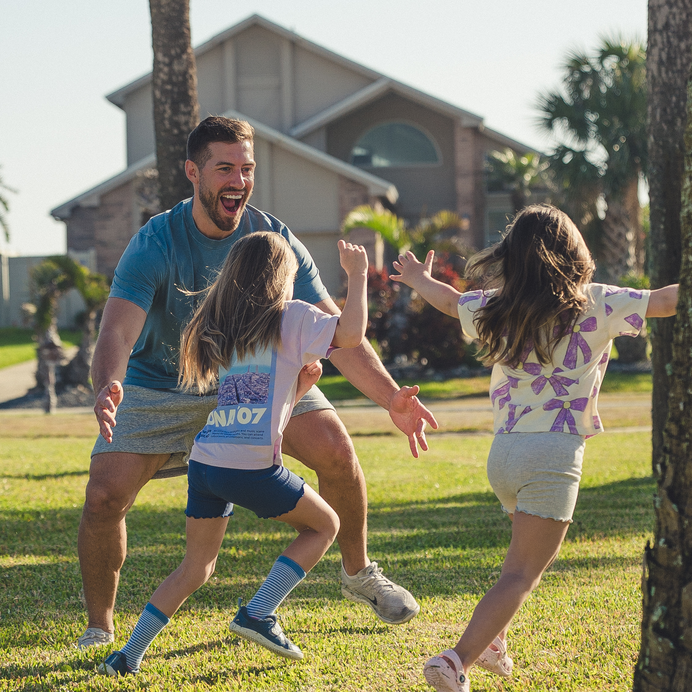 Coach Kevin playing outside with his daughters